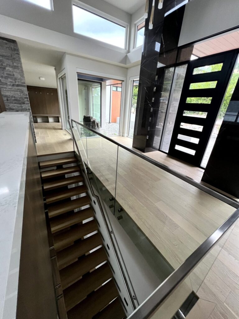 Mono Stringer Stair with an Open Rise and 3" Treads and 12mm Glass Railing, Black metal toprail and Standoffs